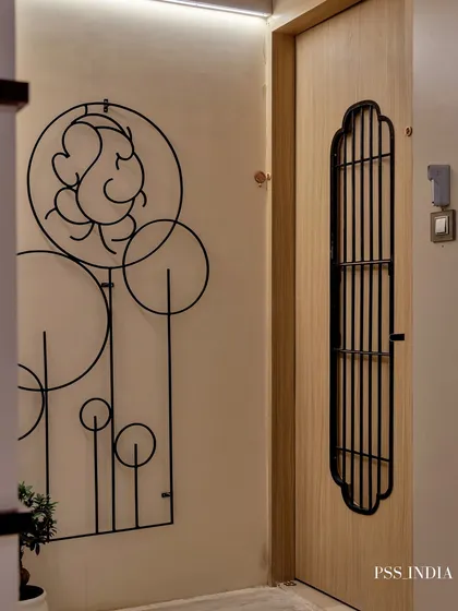 A minimalist entryway with a powerful spiritual touch. A linear metal Ganesha wall sculpture creates a beautiful focal point next to the simple, modern door.