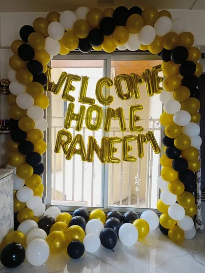 A classic 'Welcome Home' balloon arch. Using a simple and bold color combination of gold, black, and white, we created this cheerful entryway decoration to surprise a loved one.