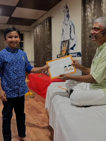 A young boy receives his certificate with a bright smile. These moments mark the beginning of what I hope is a lifelong journey with yoga.