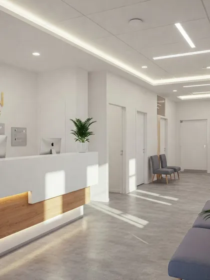 A modern and minimalist clinic reception with a sleek white and wood desk, grey floor tiles, and linear ceiling lights. The gold lettering for the logo adds a touch of elegance.