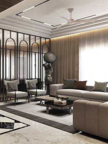The formal living area is designed with a neutral palette, allowing sculptural elements like the Atlas statue and the custom glass partition to stand out. The layout is arranged to encourage conversation and social gatherings.
