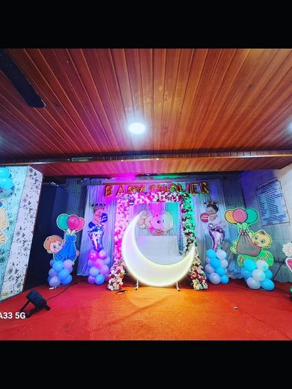 Another angle of the Cocomelon baby shower, showing the character cutouts and the simple yet effective stage on a red carpet.