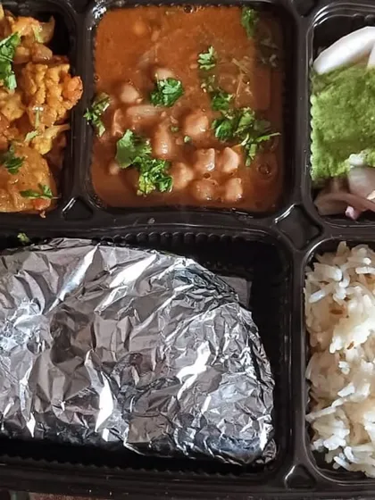 A simple and wholesome thali with Chana Masala and Aloo Gobi. This is a classic Punjabi meal that is both healthy and filling.