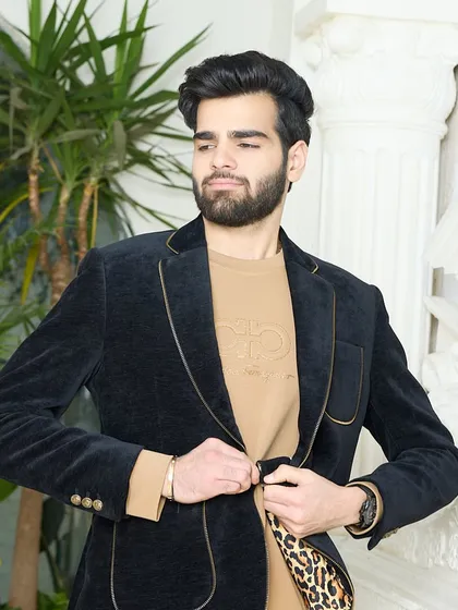 A client trying on the black corduroy blazer. The fit and feel of the luxurious fabric are evident, showcasing a piece that is both stylish and comfortable.