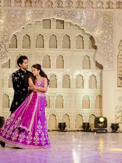 The couple sharing a dance on the custom-printed floor. The stage backdrop, inspired by Rajasthani architecture, created a grand and timeless setting for their sangeet performance.