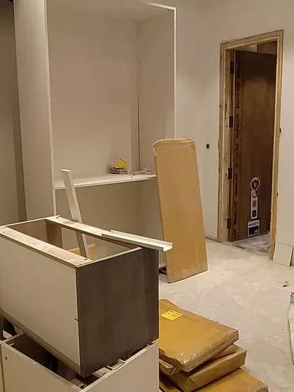 The assembly of bespoke furniture and cabinetry on site. This image shows the components of a custom wardrobe or storage unit being put together, a key part of my detailed design service.