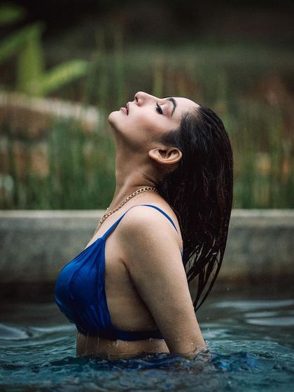 A serene moment captured during a poolside shoot. The soft, natural light and the model's relaxed pose create a feeling of tranquility and elegance.