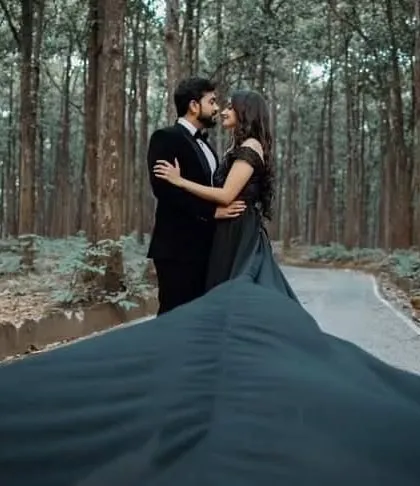 The long train of our black gown fills the frame, creating a dramatic and romantic shot on a forest road. This is a perfect example of how our gowns can transform a simple location.