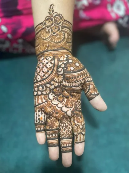 This design shows how a wrist cuff can beautifully frame the intricate work on the hand. The palm is filled with a mix of traditional patterns, perfect for any occasion.