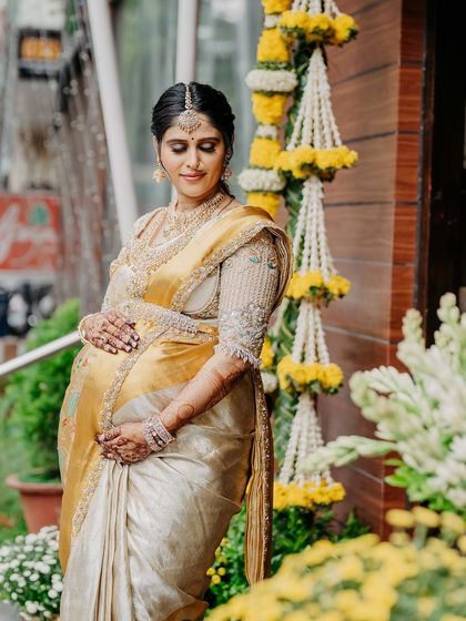 A portrait of me at the entrance of the venue, framed by floral garlands.