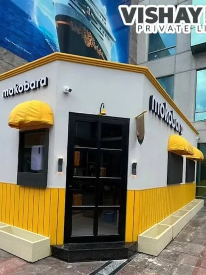 Here’s a front-on view of the Mokobara kiosk. You can see the clean lines, the glass-paneled door that offers a peek inside, and the custom yellow awnings that match the brand's colors perfectly. Every detail is designed to create a cohesive brand experience.