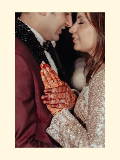 An intimate close-up focusing on the couple's hands, adorned with henna and rings. This shot symbolizes their union and the promises they've made.