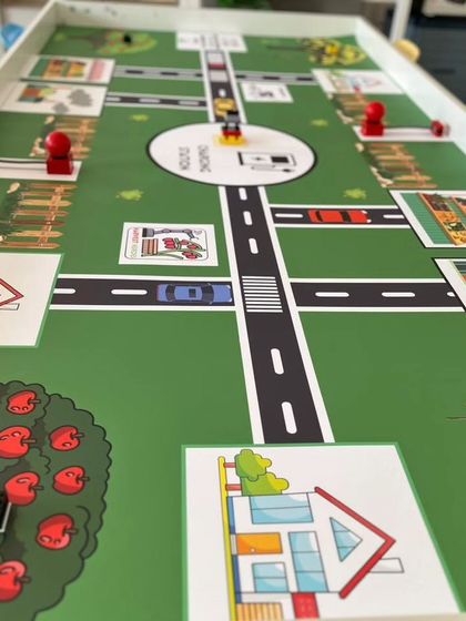 The full layout of the IRO Innovators challenge mat, showing different zones like houses, stores, and charging stations that the robot must navigate.