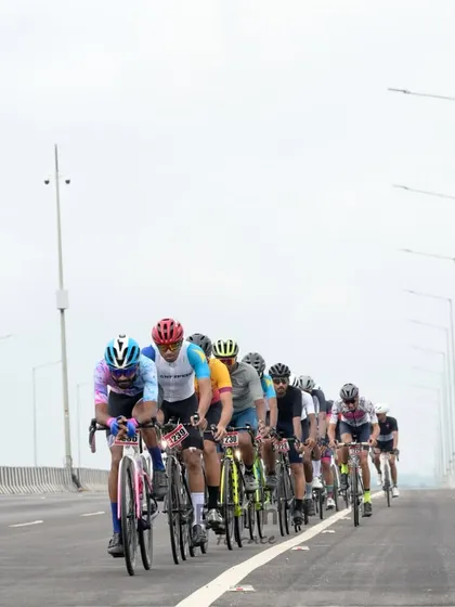 The peloton rides along a wide-open highway, a testament to the scale of our road racing events.