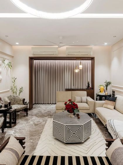 This living room is a study in contrasts, blending bold black and white geometric patterns with soft, neutral fabrics. The result is a sophisticated yet comfortable space, where every piece of furniture and decor makes a statement.
