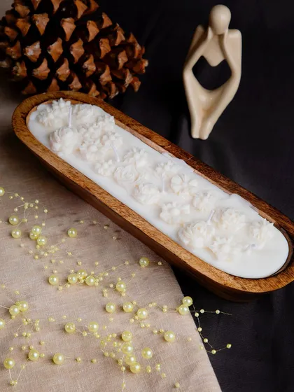 A 12-inch wooden tray soy candle, made from mango wood and filled with wax flowers, a perfect centerpiece.