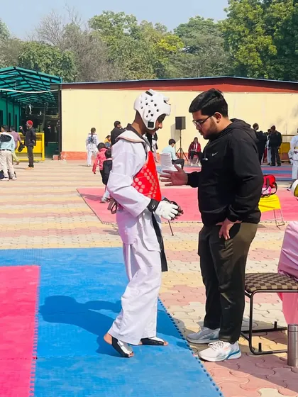 A moment of intense focus between rounds. Here, a fellow coach provides tactical guidance to Ansh Sharma during a tough match. We work as a team to support our fighters.