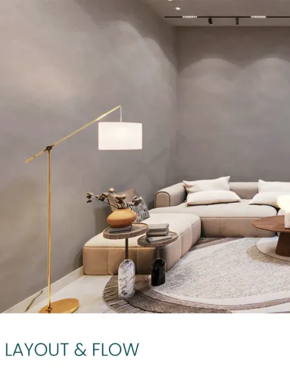 A corner of the Japandi lounge, showing the L-shaped sofa, textured gray walls, and a minimalist floor lamp. The layout and flow are designed for comfort.