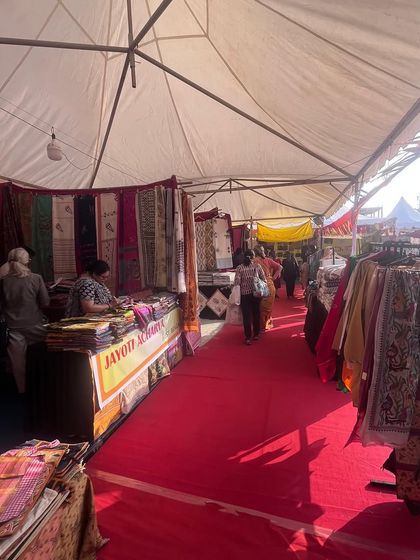 The interior of a large exhibition tent at the Dastkar Bazaar in Chennai. I provided the red carpet flooring and organized stall layouts to create a comfortable and professional shopping experience.