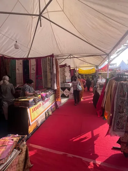 The interior of a large exhibition tent at the Dastkar Bazaar in Chennai. I provided the red carpet flooring and organized stall layouts to create a comfortable and professional shopping experience.