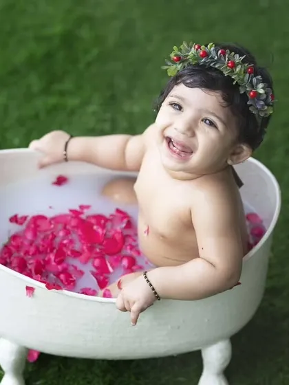 All smiles in her rosy milk bath. The flower crown adds a lovely touch to this delightful and unique baby photoshoot.