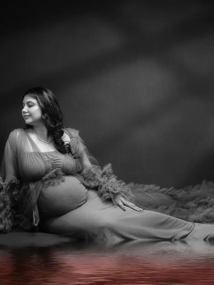 Reflecting on life's precious moments. This solo maternity photo is a masterpiece of creativity, with a color-pop reflection in the water.