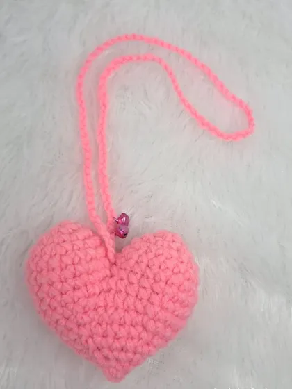 A simple and sweet pink heart ornament, perfect for hanging in a car or adding a touch of love to any space.