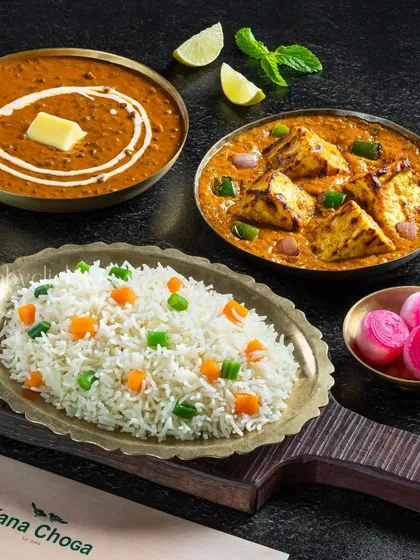 A complete meal platter from Dana Choga, featuring dal makhani, paneer kadai, and vegetable rice. The shot is styled to look like a satisfying combo.