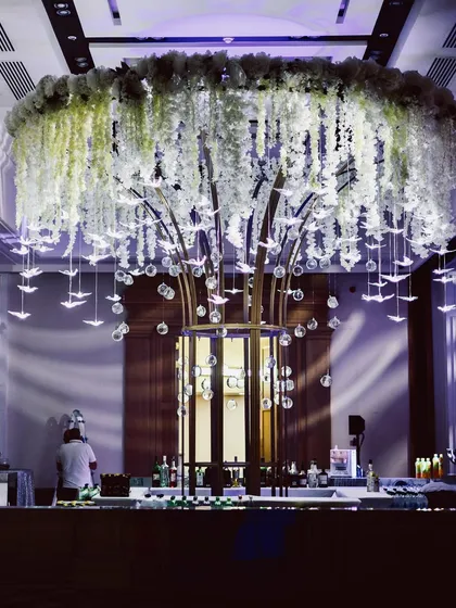 Our design philosophy is about creating breathtaking focal points. This large-scale floral chandelier, featuring cascading wisteria and delicate hanging glass birds, served as a stunning centerpiece that elevated the entire event space.