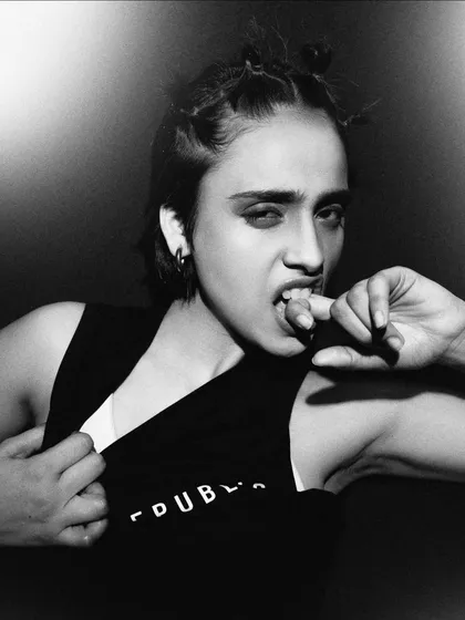 An intense and raw close-up in black and white. The model's expression is fierce and uninhibited, creating a captivating and powerful portrait.