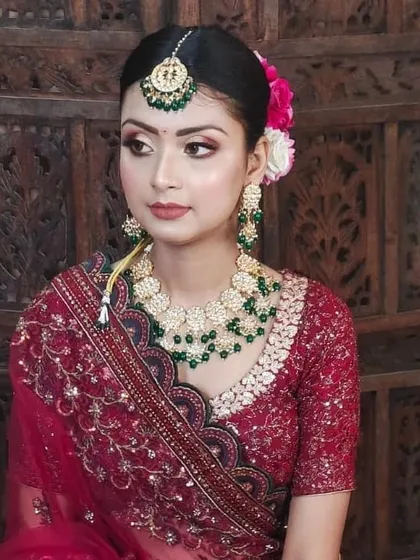 A simple and elegant look featuring a maroon blouse with delicate embroidery, paired with a Kundan and green bead necklace set.