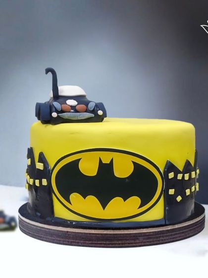 A bold and graphic Batman cake, featuring the iconic yellow and black logo and a Batmobile topper. It's the perfect cake for a birthday celebration in Gotham City.