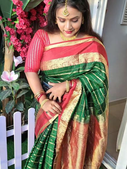 A candid shot of the client in her silk saree. The open pallu drape allows for easy movement and a graceful flow of the fabric.