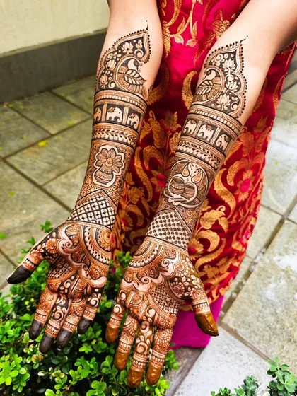 This bridal design tells a story with traditional motifs, including marching elephants and a decorative kalash.