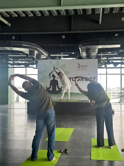 Here, I am demonstrating Tiryaka Tadasana (Swaying Palm Tree Pose) on stage while participants follow along. I ensure that even in large groups, each asana is demonstrated clearly to promote correct alignment and safety.