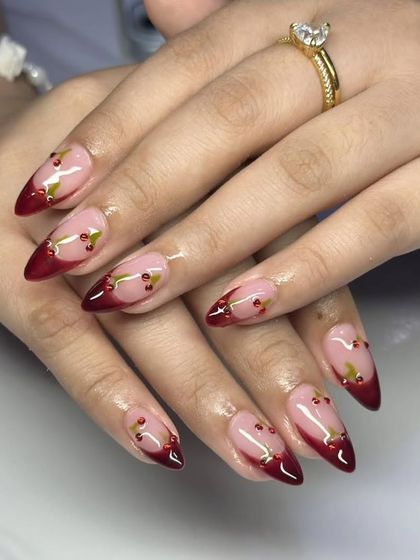A sharp stiletto set with a deep red French tip and tiny, detailed cherry accents. This design is both edgy and playful.