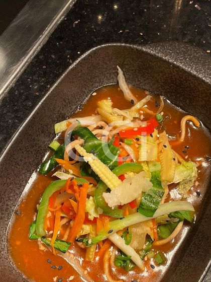 A close-up of one of our signature Pan-Asian dishes. This bowl features crisp, stir-fried vegetables like baby corn and bell peppers in a savory sauce, delivering authentic Asian flavors perfect for any luxury gathering.