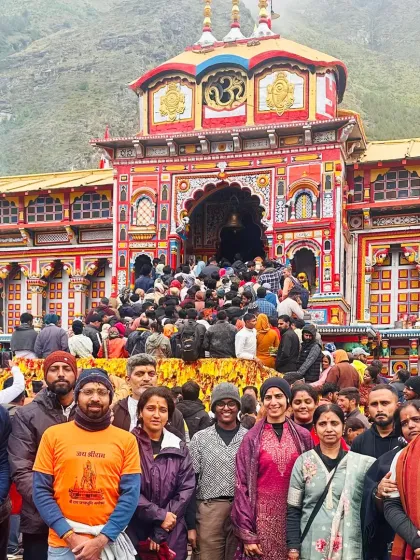 A group photo in front of the colorful and vibrant Badrinath temple. Our Char Dham yatra packages often include visits to both Kedarnath and Badrinath.