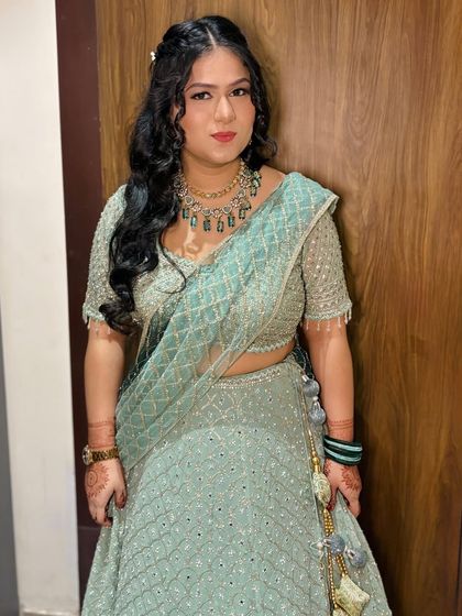 A full-length portrait of the client in the blue lehenga.