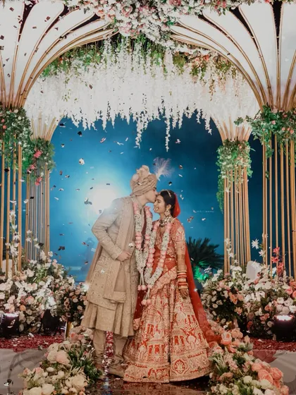 A perfect moment under a sky of confetti and a canopy of flowers. We focus on capturing these grand, fairytale moments that feel like they are straight out of a movie, ensuring your wedding photos are as magical as the day itself.