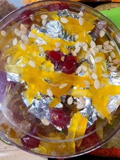 A top-down view of the mixed fruit murabba, showing the sprinkle of sesame seeds and the beautiful silver leaf garnish. This is a premium homemade sweet preserve, ideal for Diwali or as a wedding favour.