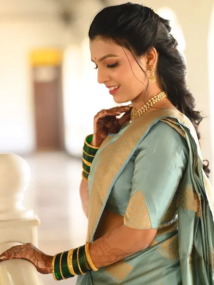 A side profile showcasing the soft makeup and simple pearl necklace, creating a look of understated elegance.