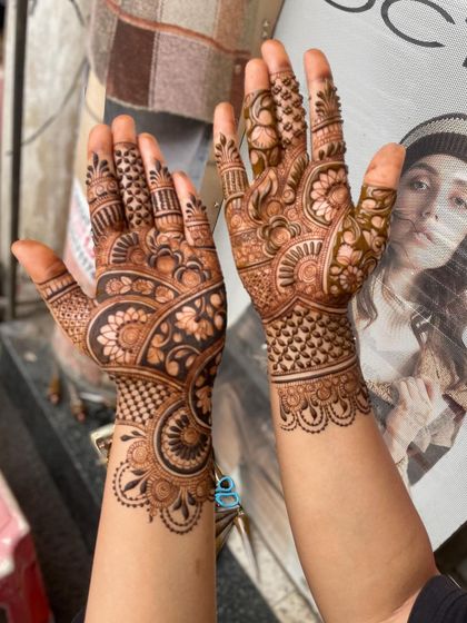 A beautiful, full-hand design with a mix of floral, paisley, and check patterns. This is a classic and timeless mehandi style.