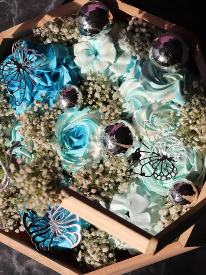 An overhead view of the blue cupcake arrangement in its wooden basket.