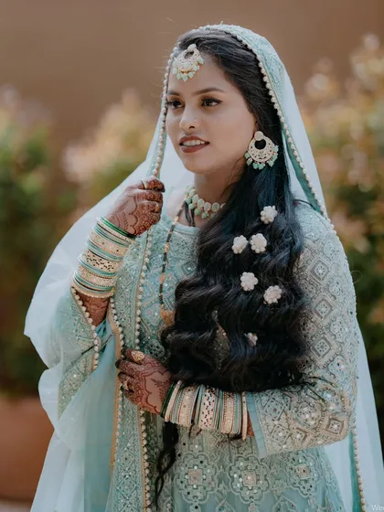 A stunning portrait of a Muslim bride in her beautiful light blue attire, with delicate flowers in her hair.
