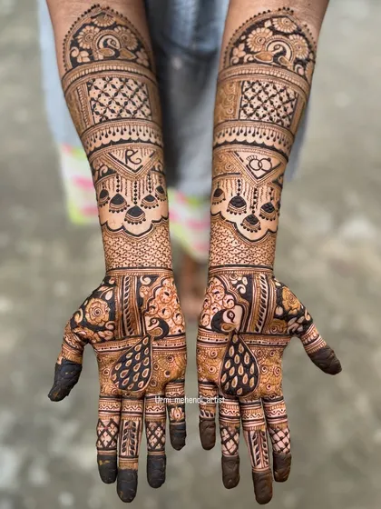 A gorgeous engagement mehendi with the couple's initials 'R' and 'C' hidden in the design. The pattern is a beautiful mix of traditional peacock and geometric elements.