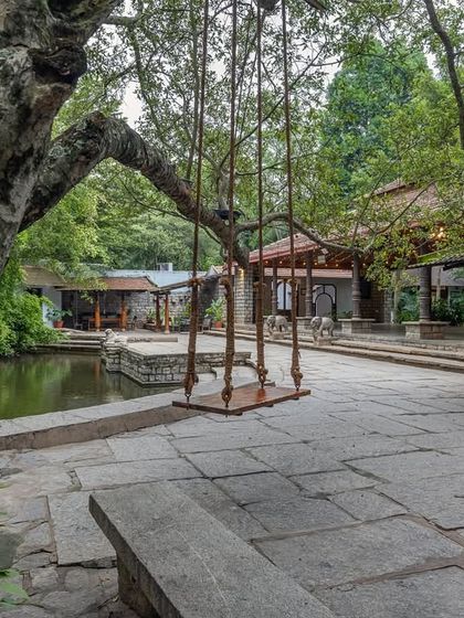 A view of the stone-paved courtyard featuring our iconic swing, with the Pond Pavilion in the background. This highlights the blend of natural and architectural beauty at our venue.