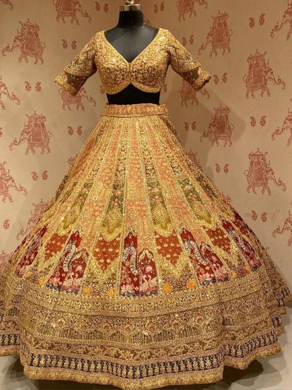 Another view of our multi-color panelled bridal lehenga. The golden blouse and the heavily embroidered skirt create a look of unmatched grandeur, available for you to rent.