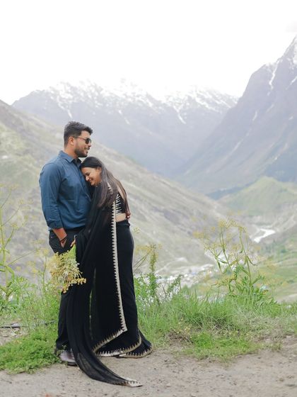 A sweet and intimate pose with the bride resting her head on her partner's shoulder, set against the vast mountain valley.