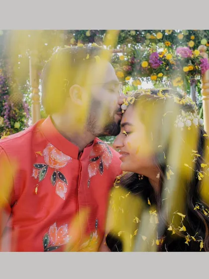 A close, romantic moment amidst a shower of flower petals. This shot beautifully combines the tenderness of their relationship with the fun, floral theme of their personalized shoot.
